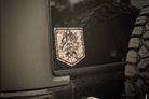 Duck Camouflage-style decal on a vehicle with 'Stay the Course' text, next to a tire.