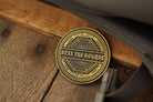 antique brass coin with 'Stay the Course' inscription on a wooden surface