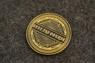 Antique brass coin with 'Stay the Course' text on a textured brown background
