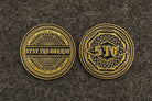 Two antique brass coins with intricate designs and text on a dark textured background
