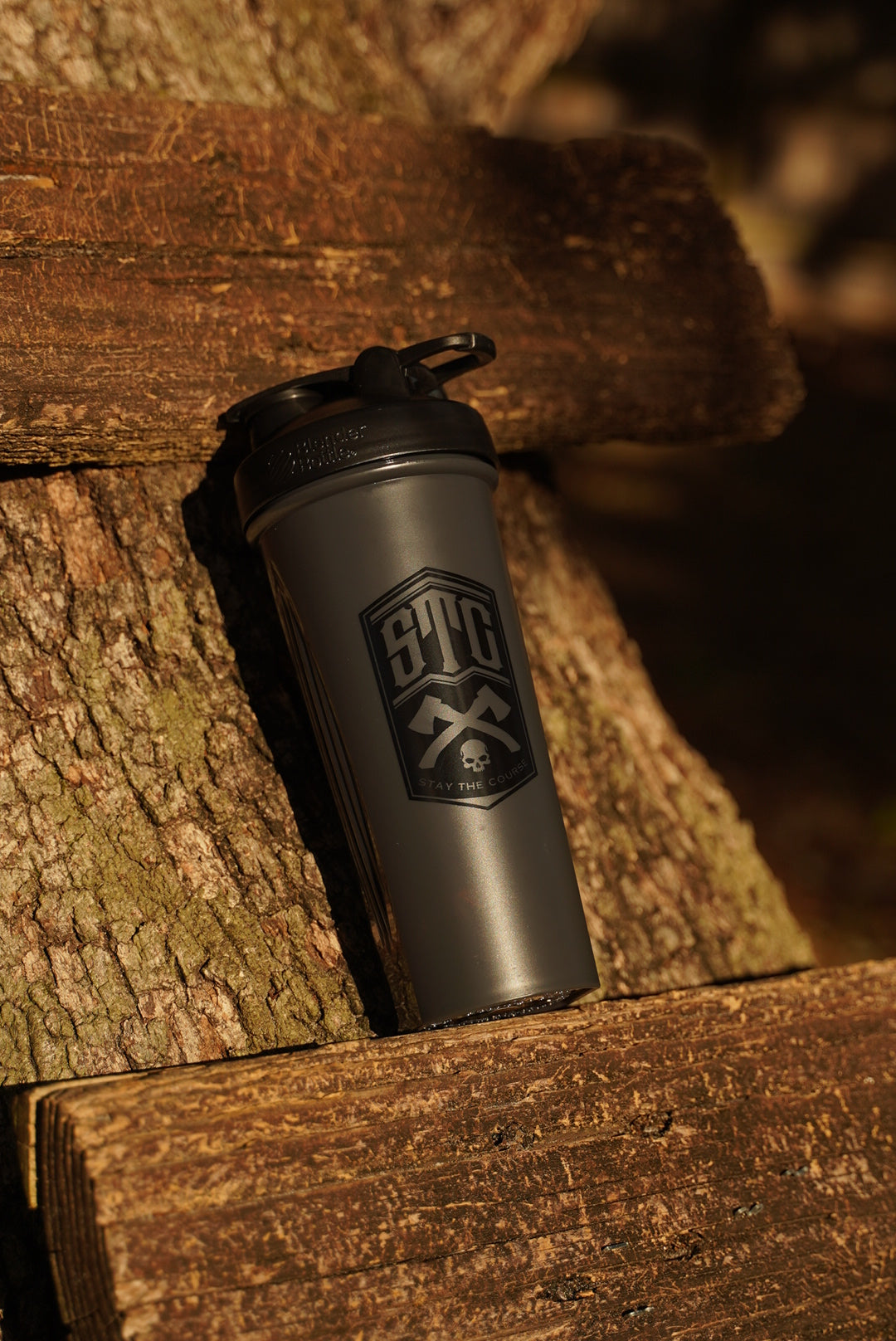 Black shaker bottle with a STC logo on a wooden surface