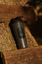 Black shaker bottle with a STC logo on a wooden surface