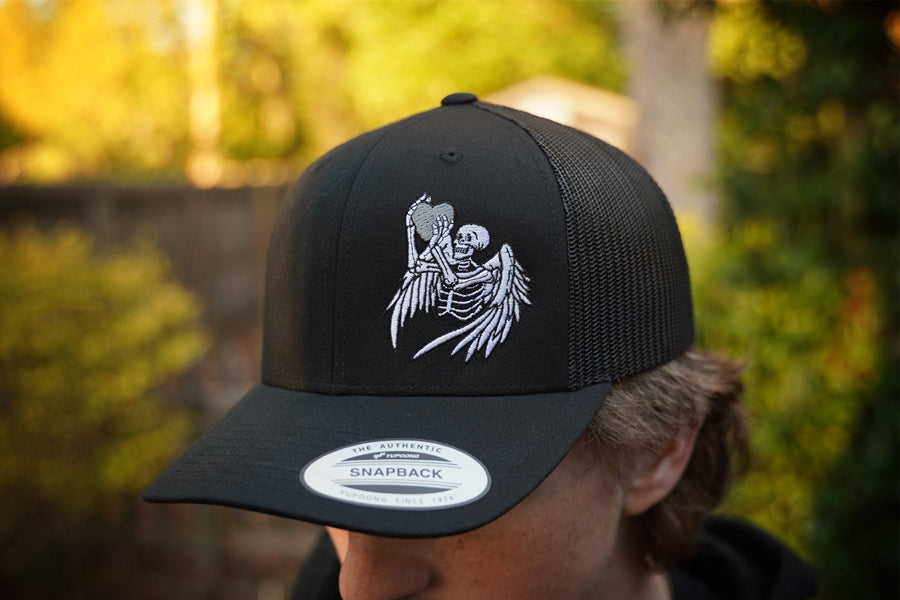 Black cap with skeleton design worn by a person outdoors