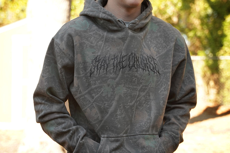 Person wearing a deadwood camo hoodie outdoors