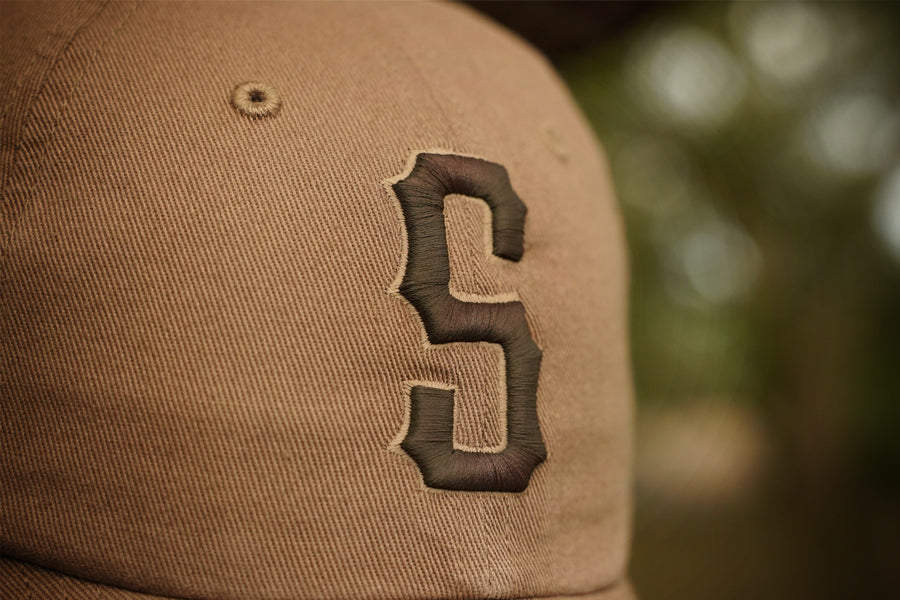 Brown cap with a logo on a blurred natural background
