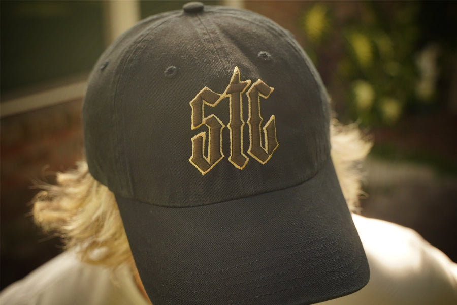 Black cap with gold and brown embroidery on a blurred background