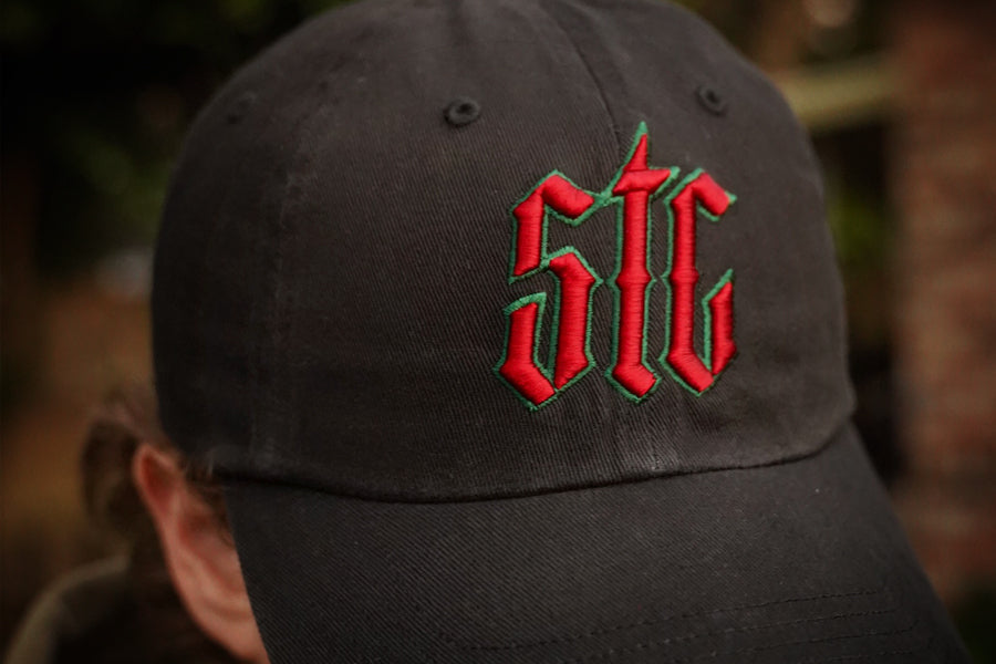 Black cap with red and green logo on a blurred background
