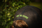 Person wearing a cap with 'Stay the Course' text against a blurred green background