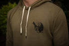 Military green hoodie with a black graphic design on the chest against a dark background