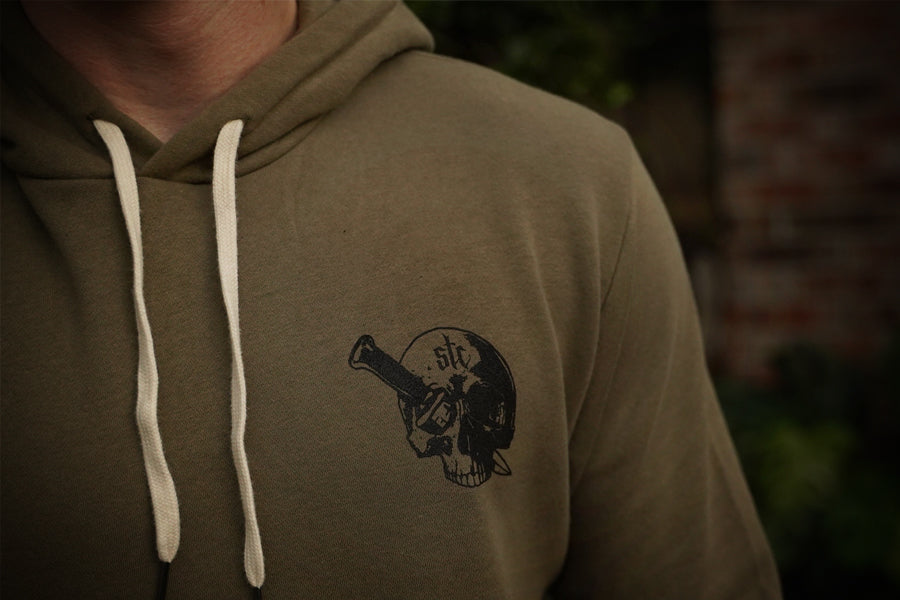 Green hoodie with a black skull design on the chest, blurred background
