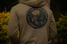 Person wearing a hoodie with a skull design and text on the back, standing outdoors.