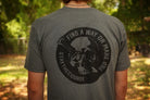 Person wearing a gray shirt with black graphic print that says "Find a way or make one - Stay the Course"