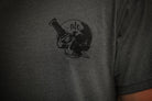 Person wearing a gray shirt with black graphic of a skull and dagger