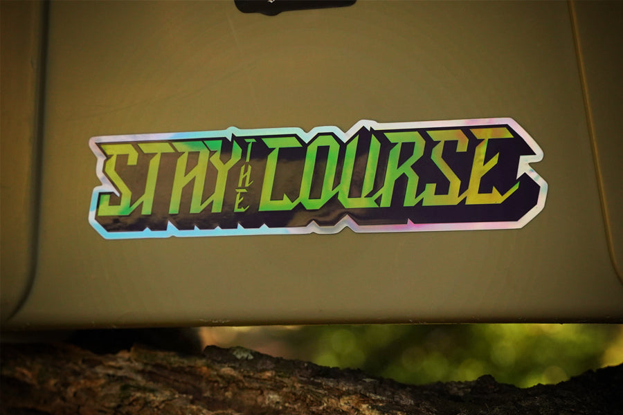 Sticker with 'Stay the Course' text on a beige surface