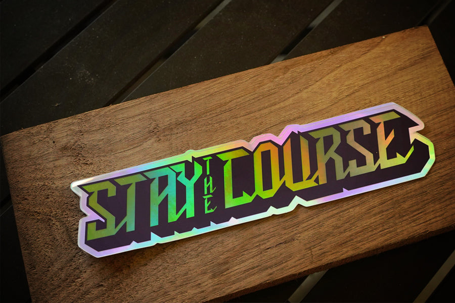 Holographic 'Stay the Course' sticker on a wooden surface