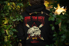 Person wearing a black hoodie with a graphic design and text in a forest setting