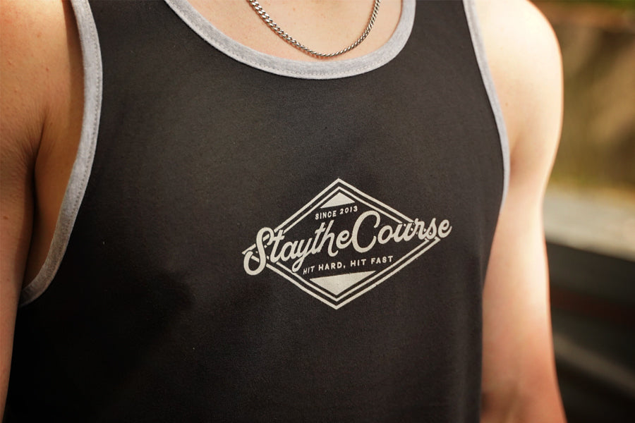 Person wearing a black tank top with 'Stay the Course' logo.