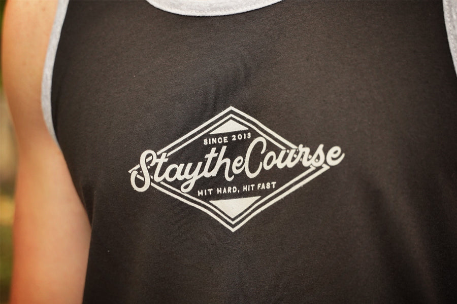 Black tank top with 'Stay the Course' logo on a blurred background