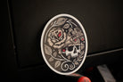 Decorative sticker with skull and rose design on a dark background