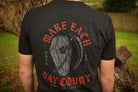 Person wearing a black t-shirt with red and gray graphic design outdoors.
