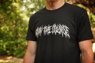 Person wearing a black T-shirt with "Stay the Course" printed in white in heavy metal style