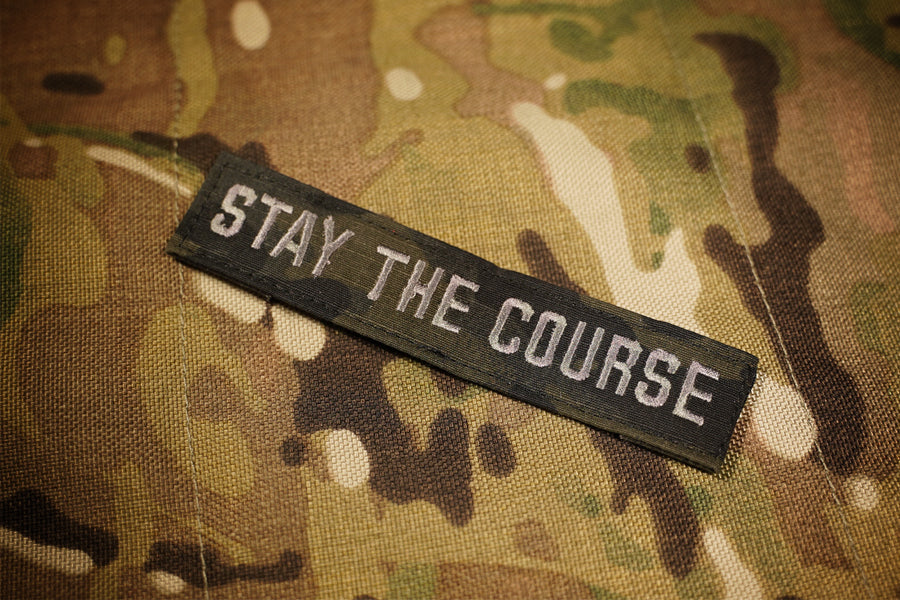 Black camouflage patch reading 'STAY THE COURSE'