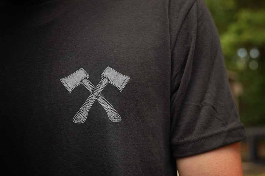 Black t-shirt with crossed axes design on the back, blurred background