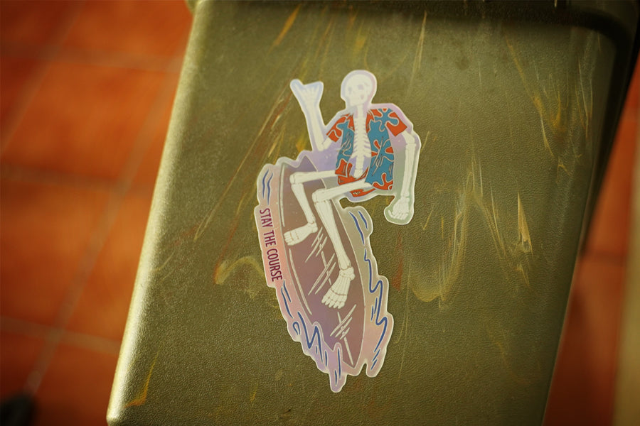 Sticker with a design of a skeleton on a surfboard on a green surface