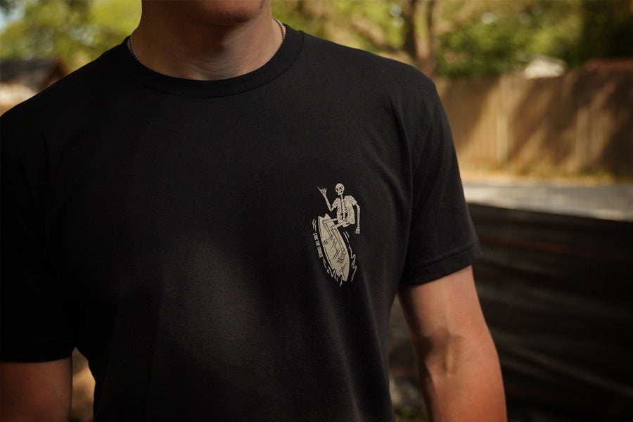 Person wearing a black t-shirt with an off white graphic design outdoors