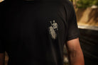 Black t-shirt with a white graphic on the back, worn by a person.