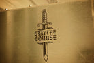 White vinyl decal of dagger and "stay the course" on metal cabinet