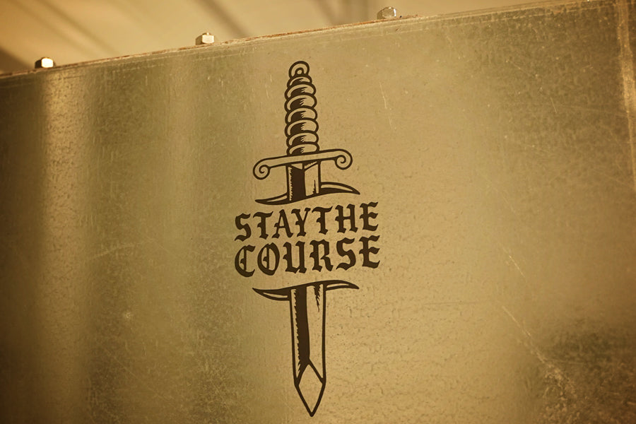 White vinyl decal of dagger and "stay the course" on metal cabinet