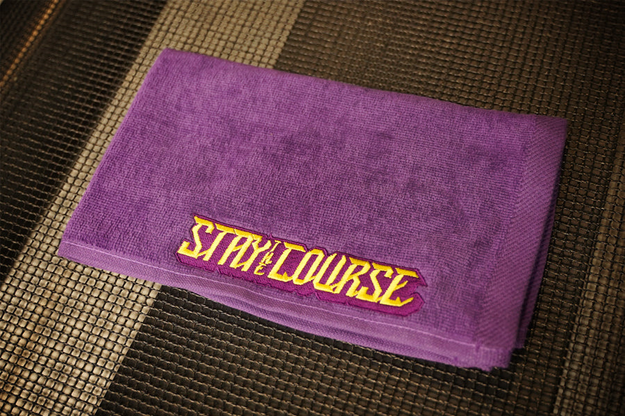 Purple hand towel with yellow embroidered "Stay the Course"