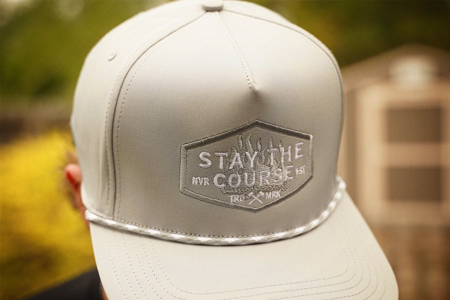 Gray cap with 'Stay the Course' logo on a blurred background