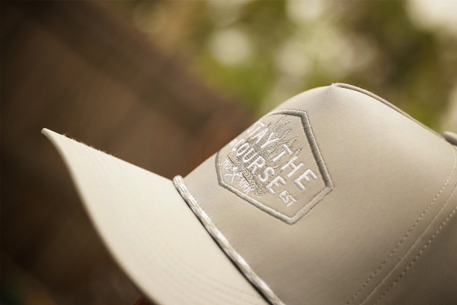 gray cap with a logo on a blurred natural background