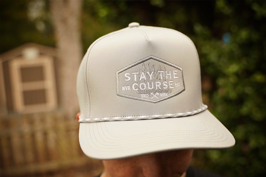 gray cap with 'Stay the Course' logo on a blurred background