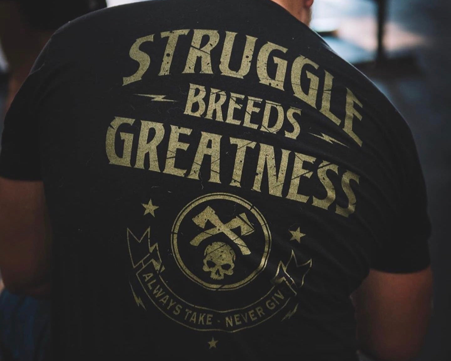 Black t-shirt with 'Struggle Breeds Greatness' text and graphic design on the back.