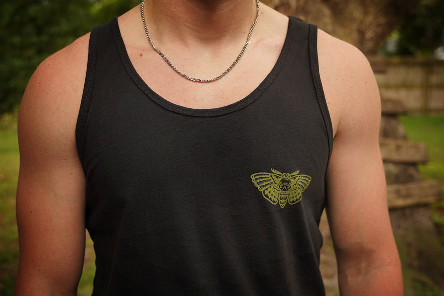 Person wearing a black tank top with a green logo outdoors