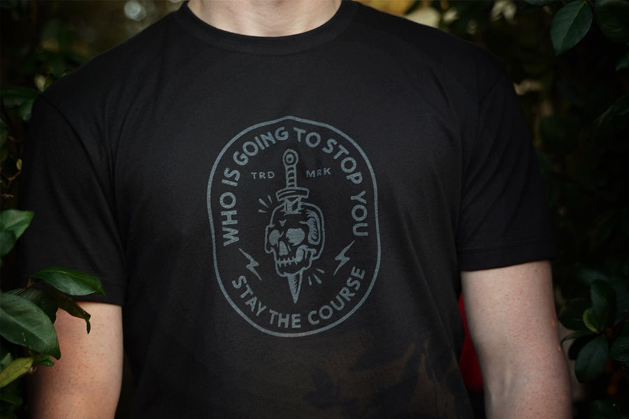 Person wearing a black t-shirt with a graphic design and text.