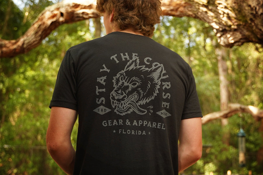 Person wearing a black t-shirt with gray print of wolfhound head and "stay the Course"