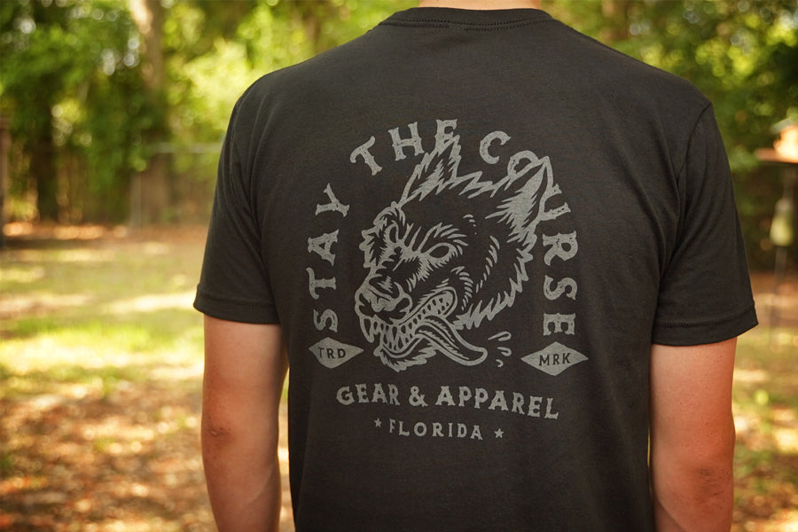 Person wearing a black t-shirt with gray print of wolfhound head and "stay the Course"